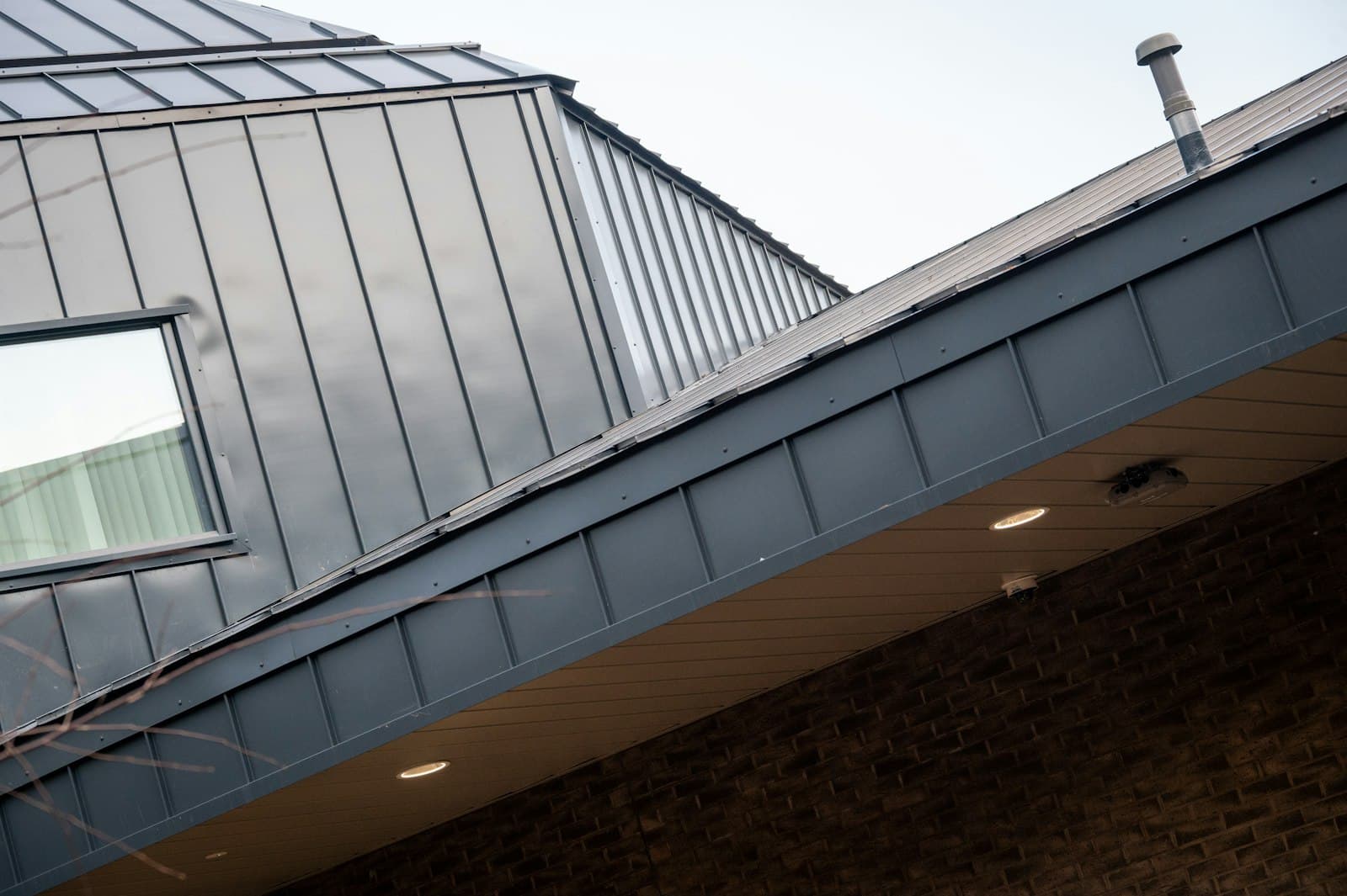 Close-up of a freshly-installed zinc standing-seam roof on a contemporary extension.