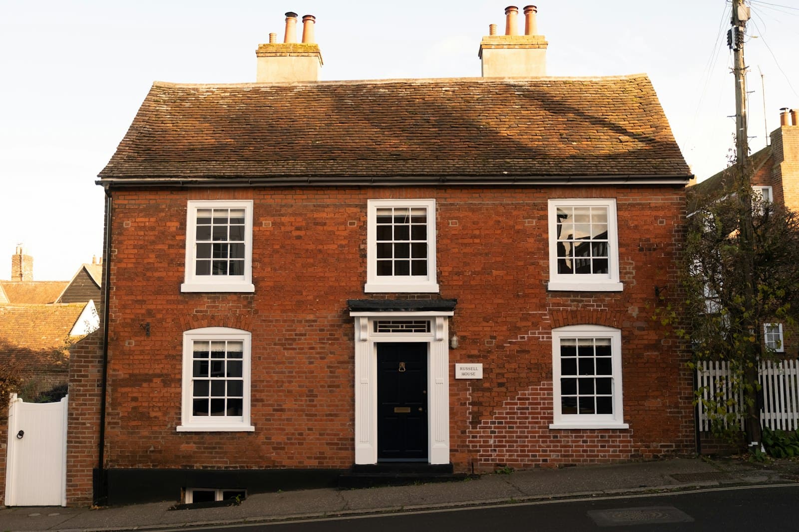 Georgian red-brick vicarage with a pitched clay tile roof and twin chimneys.